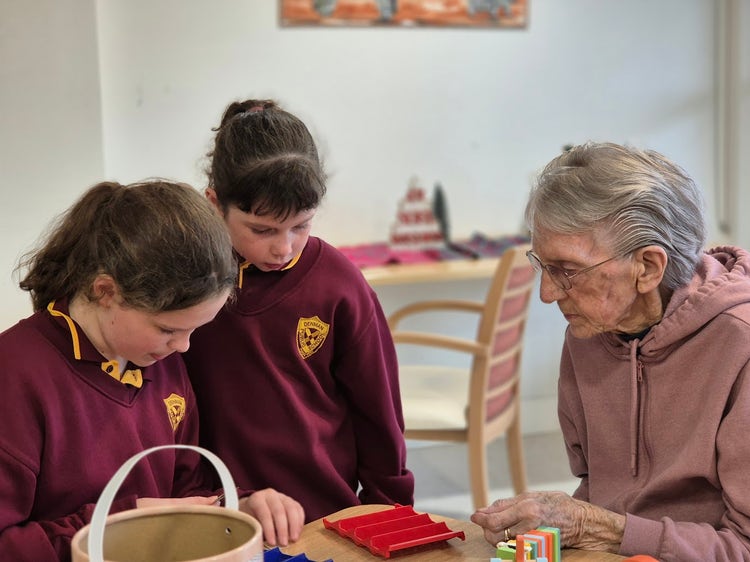 Two students interacting with older lady